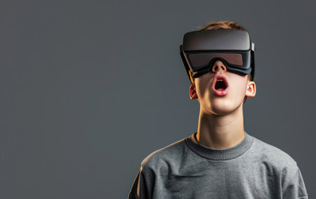 Surprised teen student in VR glasses explores virtual space.の写真素材