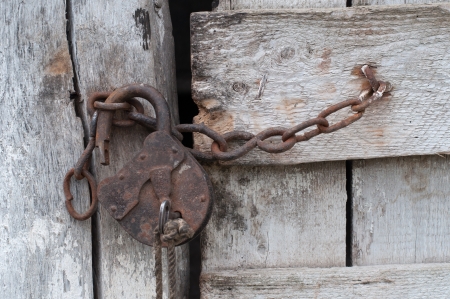 Lock with a chain on an old wooden doorの写真素材