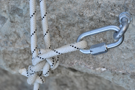 Iron piton in a granite rock with ropeの写真素材