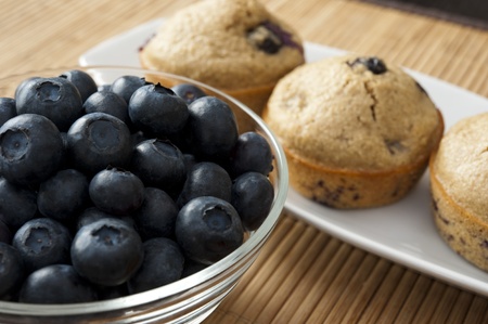 Bowl of blueberries with blueberry muffinsの写真素材