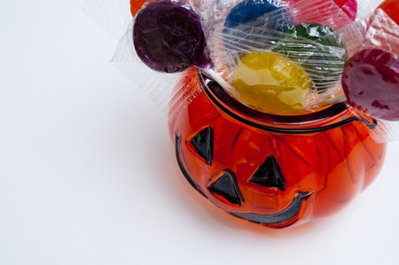 Glass Jack-o-lantern filled with lollipops of assorted colorsの写真素材