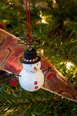 Snowman ornament hanging on a Christmas treeの写真素材