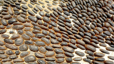 View of old cobble paving road for background. Closeup of a road with pebbles. Greece