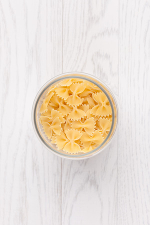 Pasta in glass pot on white wooden backgroundの写真素材