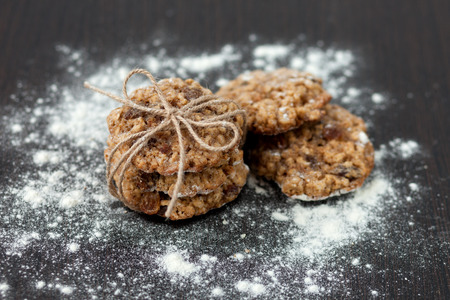 oatmeal cookies with raisins and flour on wooden tableの写真素材