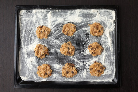 uncooked oatmeal cookies with raisins on baking tray