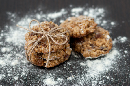 oatmeal cookies with raisins and flour on wooden tableの写真素材