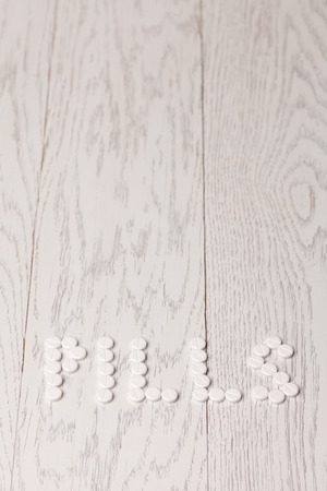 Word pills of white tablets on wooden tableの写真素材