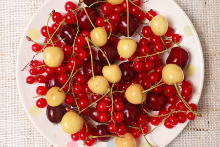 Mixed red and yellow berries in bowl on tableの写真素材