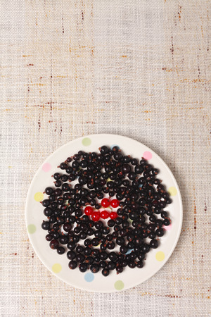 Black and red currants in a bowl on tableの写真素材
