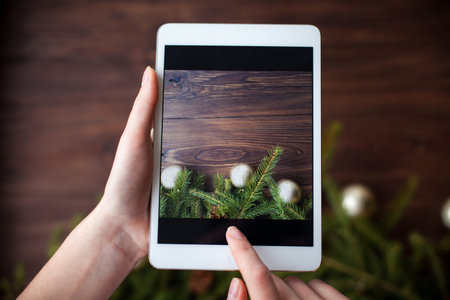 Taking picture with tablet on brown wooden backgroundの写真素材