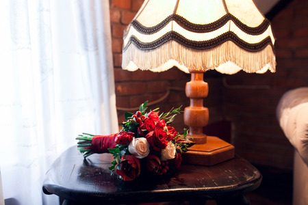 Red bouquet on table near window nature lightの写真素材