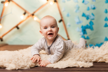 Small cute baby lying on carpet  lifestyle in studioの写真素材