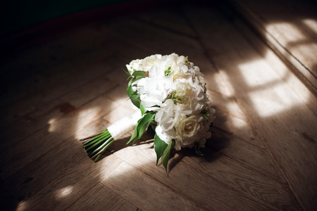 Wedding bouquet with white roses on floor, natural light from window backgroundの写真素材