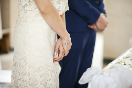 Closeup image of brides hands on marriage ceremony inside church blur backgroundの写真素材