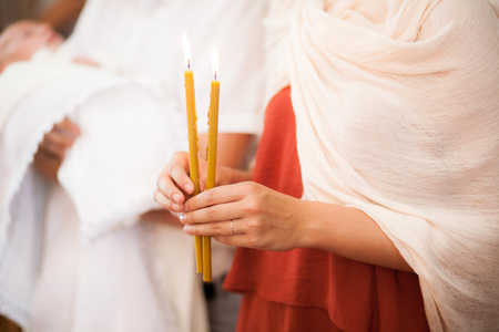 Woman hold in hands two candels in churchの写真素材