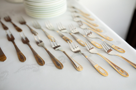 Decorated luxury cutlery on table with golden elements forks nature lightの写真素材