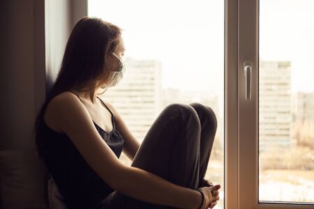 Portrait of young girl with ear loop face mask, close upの写真素材