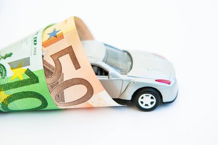 White toy car wrapped in the banknotes 50 and 100 eurosの写真素材