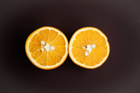 Two halfs of oranges on brown background. Copy spaceの写真素材