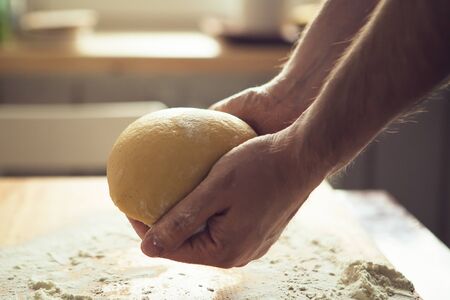 Man's hands kneading dough. Dough in somebody's hands