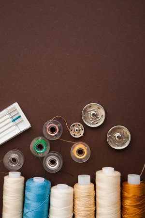 Sewing tools on the dark brown background with the copy space for your text