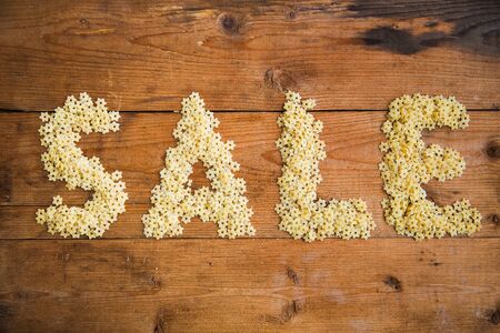 Word SALE made from pasta, spaghetti on the wooden backgroundの写真素材