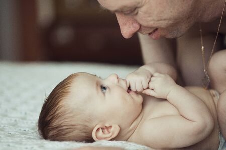 Newborn baby playing with his father, close upの写真素材