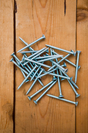 Set of metalware, bolts on the wooden background