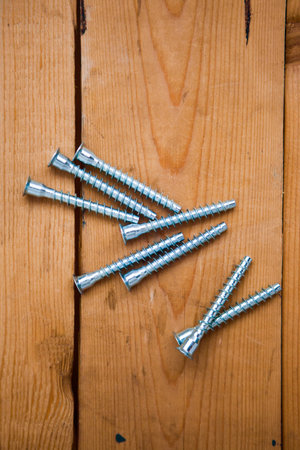 Set of metalware, bolts on the wooden background