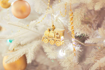 White Christmas tree with gold christmas train toy, close upの写真素材