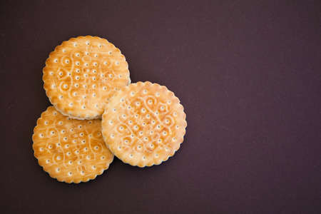Three round cookies on the dark brown background with copy space for your textの写真素材