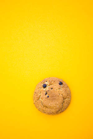 Round smiling cookie on the yellow background with copy space for text. Oatmealの写真素材