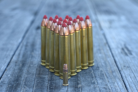 Red tip 450 and 22  Caliber ammunition on wooden backgroundの写真素材