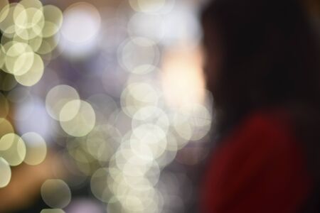 Shadow of girl in red shirt on the blurred Christmas light bokeh backgroundの写真素材