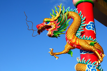 Gold Chinese dragon in front of a blue sky の写真素材