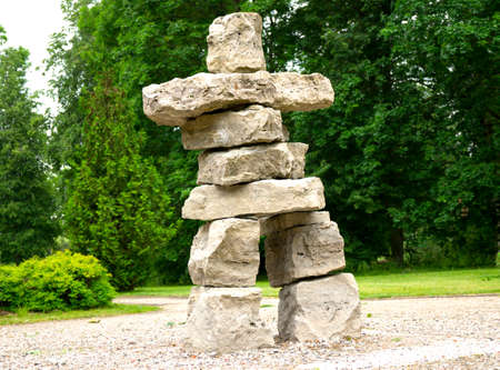 primitive simple big huge man sculpture from bright square stones park summerの写真素材