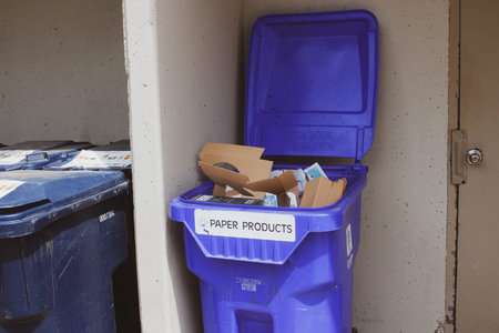 garbage bins are overfilled with packages with waste on the road against the background of the white...