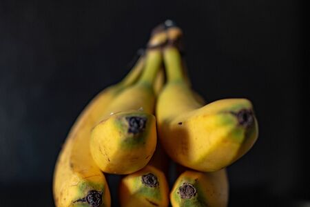 Ripe banana group on a black background. Fruit photographyの写真素材