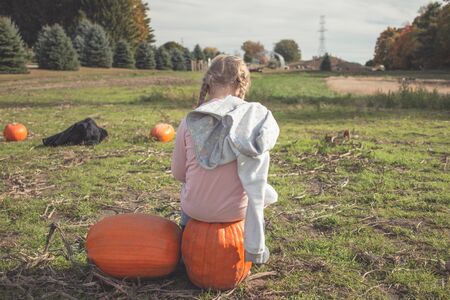 little girl in a pumpkin patch in Canadaの写真素材
