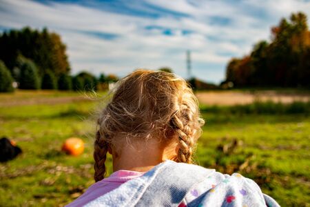 little girl in a pumpkin patch in Canadaの写真素材