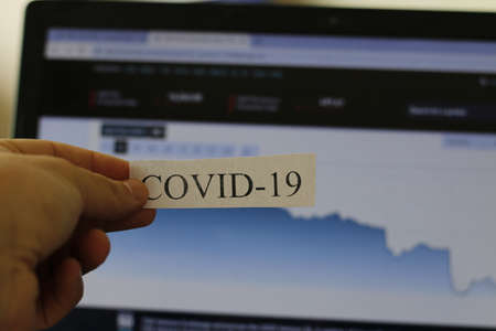 London Canada, March 01 2020: Editorial illustrative photo of COVID-19 in front of the toronto stock exchange, tsx, graph. The stock market has been crashingのeditorial素材