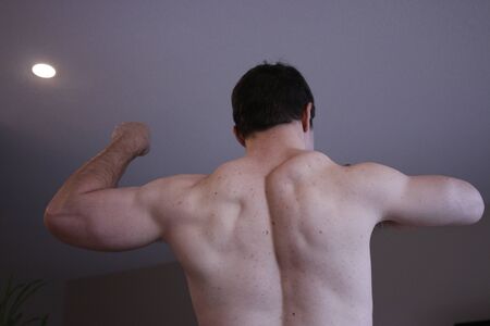 man flexing back in selfie type photoの写真素材