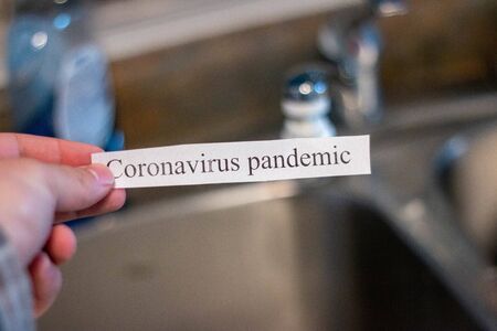 Coronavirus in front of a sink. Theme of washing hands to avoid contracting covid-19の写真素材