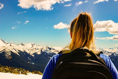 Travel Canada. Woman on mountain cliff against snow capped peak. Vancouver, Whistler. Stawamus Chief Park near Squamish. British Columbia. Canada..の写真素材