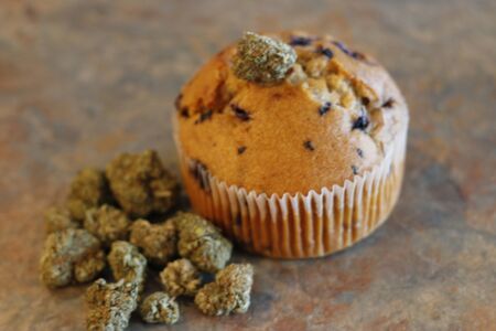 A cannabis muffin next to a bunch of marijuana buds.の写真素材