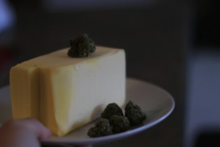 Cannabutter process of making. Buds of marijuana in front of a stick of butterの写真素材