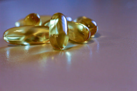 Close up yellow Cod Liver Oil capsule on white background, fish oil is a dietary supplement derived...