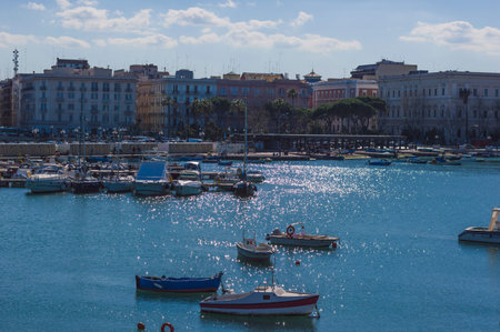 BARI, ITALY - FEBRUARY 16, 2020: small boats moored at Bari fishing harbor on background of city embankmentのeditorial素材