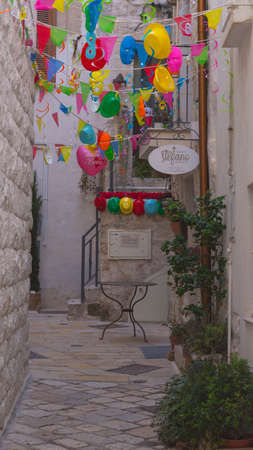 POLIGNANO A MARE, ITALY - FEBRUARY 17, 2020: narrow street decorated with bright garlandsのeditorial素材
